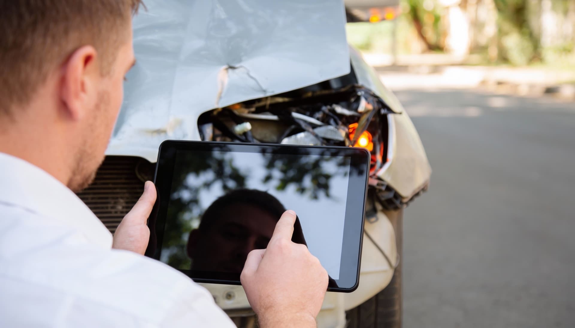 Vehicle assessor using tablet to inspect car damage